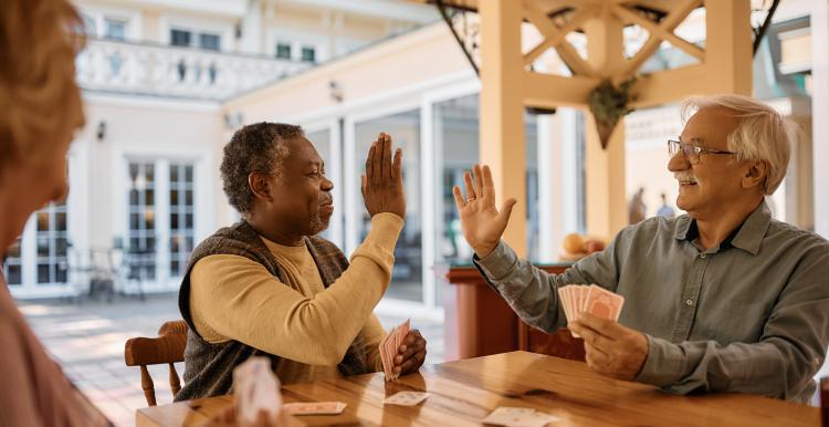 Elderly men high fiving each other.