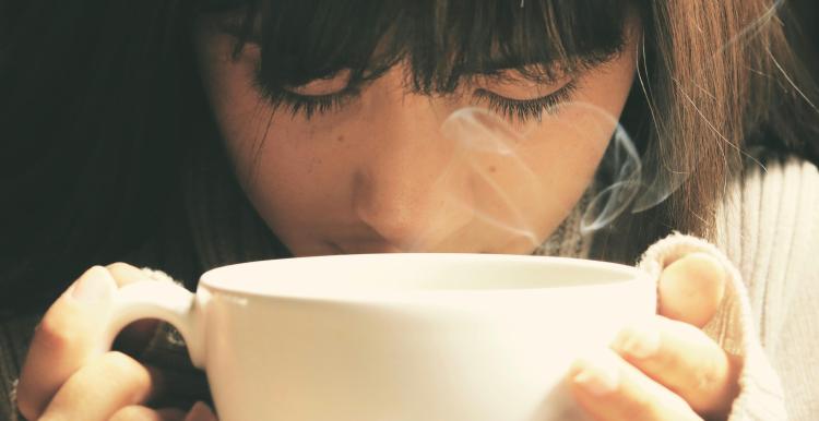 young girl holding a cup of tea