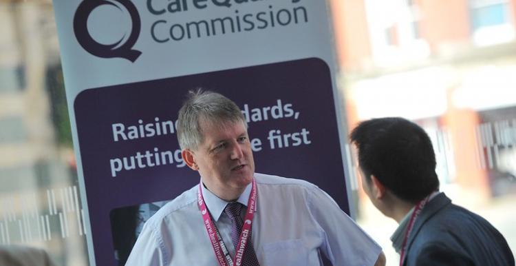 A man standing in front of a CQC sign