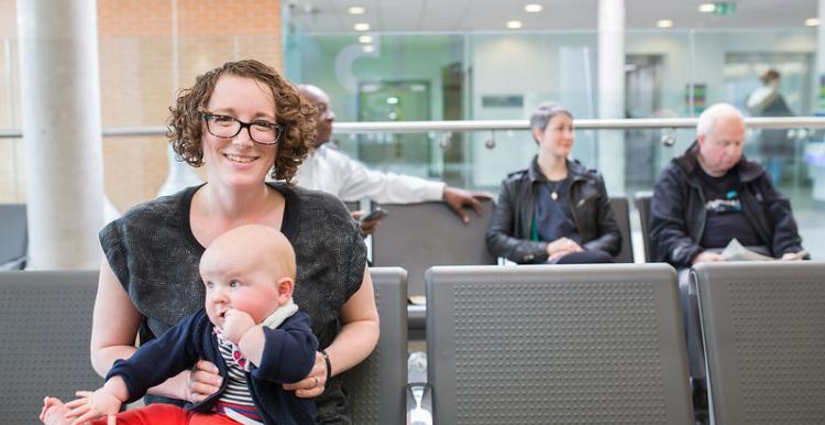 A mother and baby waiting in a waiting room