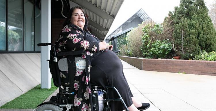 A lady in a wheelchair sitting outside