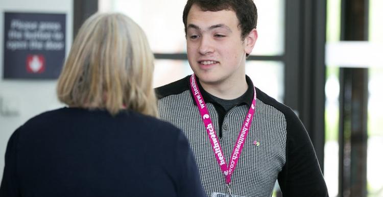 A young man talking to an older lady