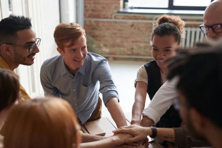 A group of young smiling people huddled together