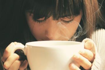 young girl holding a cup of tea