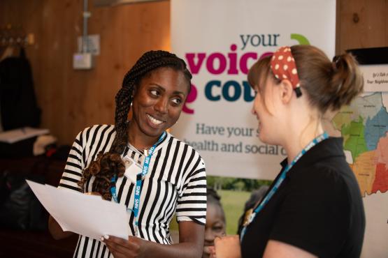 Two women sharing insights at conference.