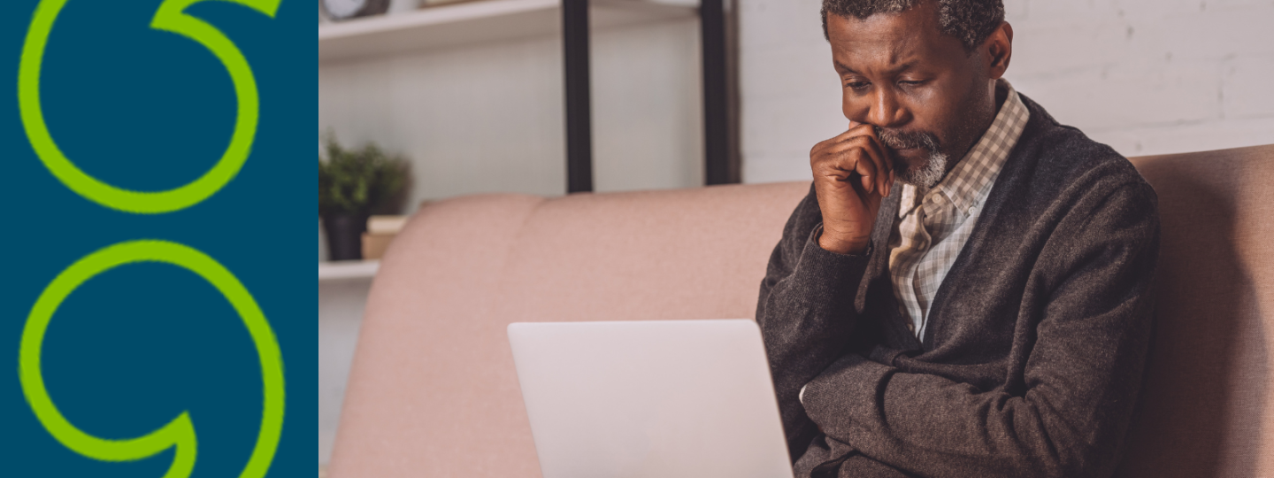 Man looking at laptop while sitting on sofa