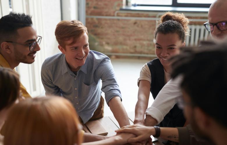 A group of young smiling people huddled together